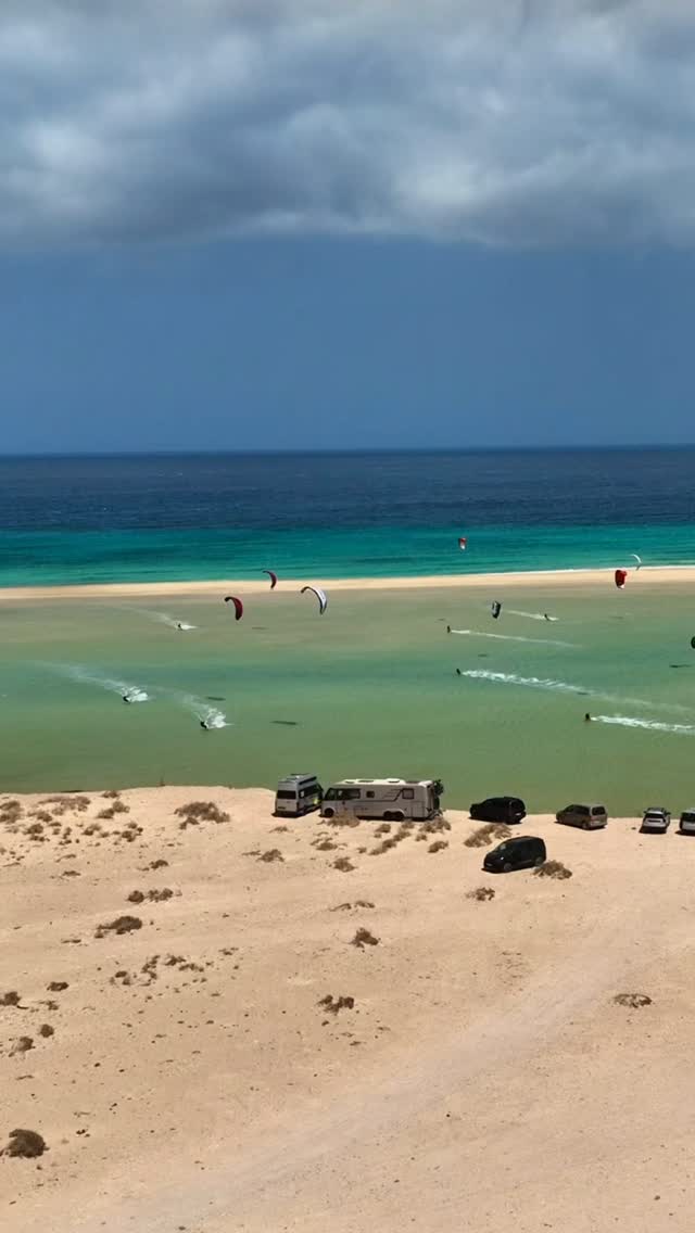 Kitesurfers enjoying their Kite at Vantures kite camp kitesessions by a Hymer camper parked on the beach at Sotavento in Fuerteventura.